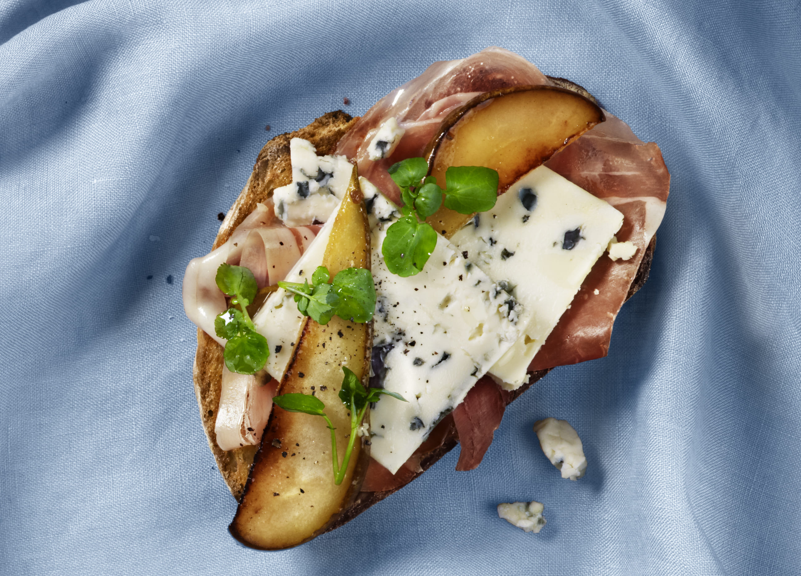 Åben sandwich med prosciutto og pære